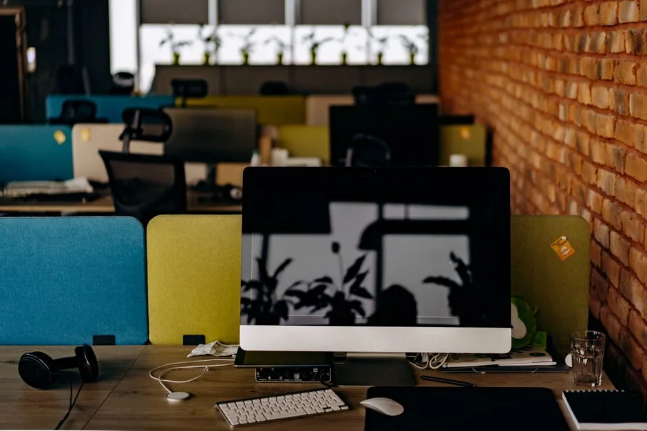 Un espace de travail moderne avec deux écrans d’ordinateur affichant des projets de web design, mettant en avant la technologie et la productivité.